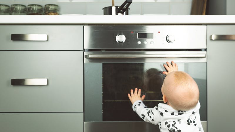 Baby playing with an electric oven